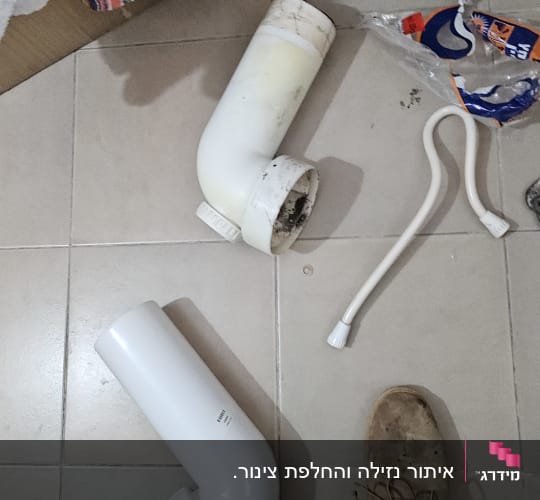 חלקי צנרת וכלים על רצפת חדר אמבטיה